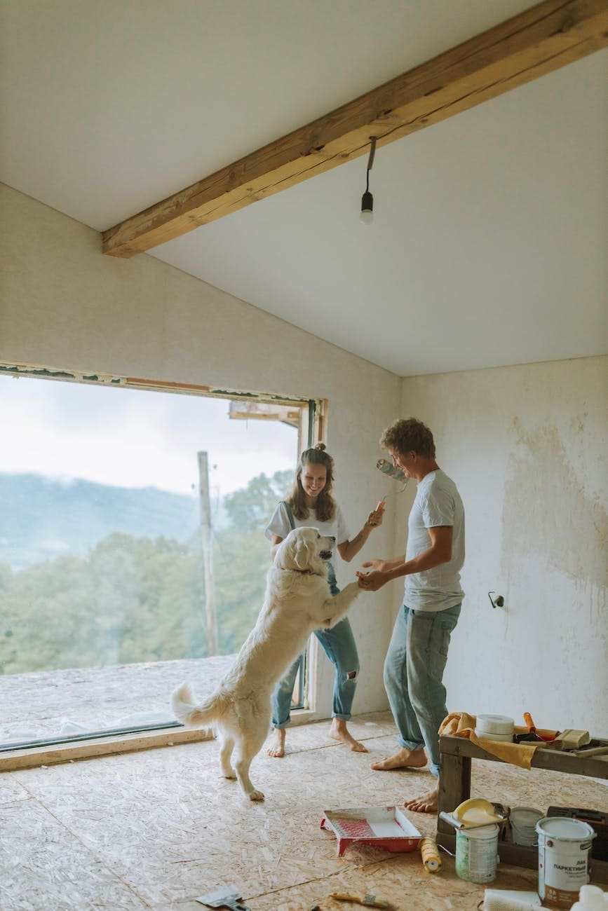 Home Remodeling Mistakes Couples Should Avoid man and woman playing with their dog while doing renovation